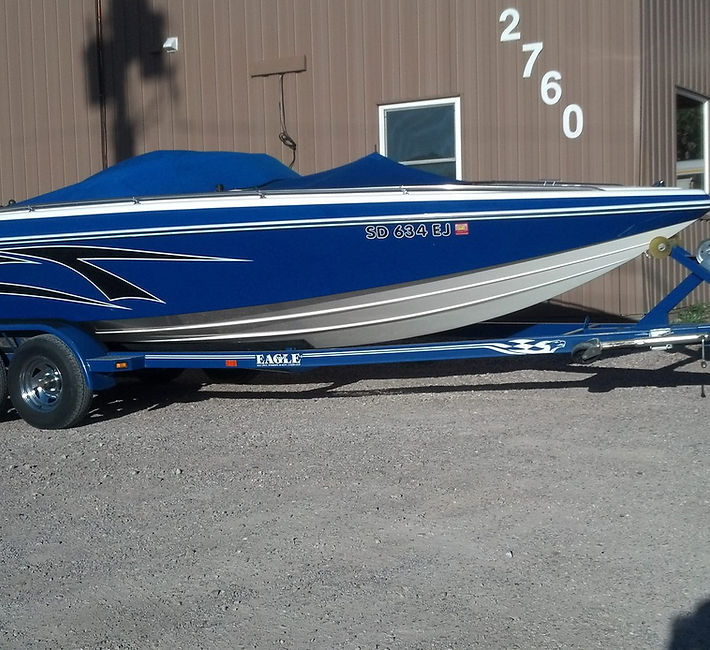 Blue and silver speedboat with custom graphics on a matching trailer