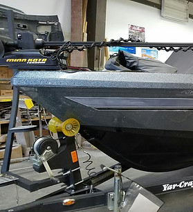 Aluminum fishing boat on a trailer inside the shop for repair work