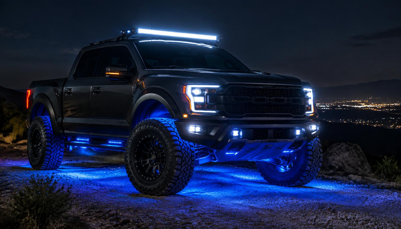 Truck with a roof mounted LED light bar and blue underbody lighting glowing at night